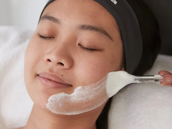 woman receiving treatment on face with fan brush
