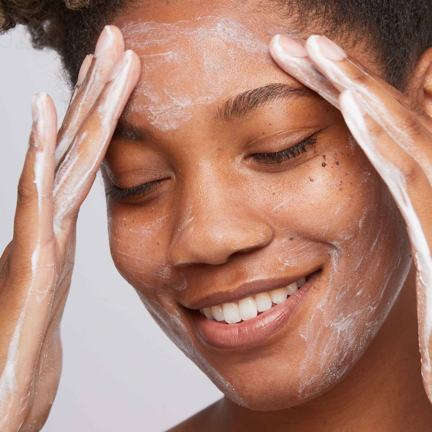 woman cleansing face with daily microfoliant