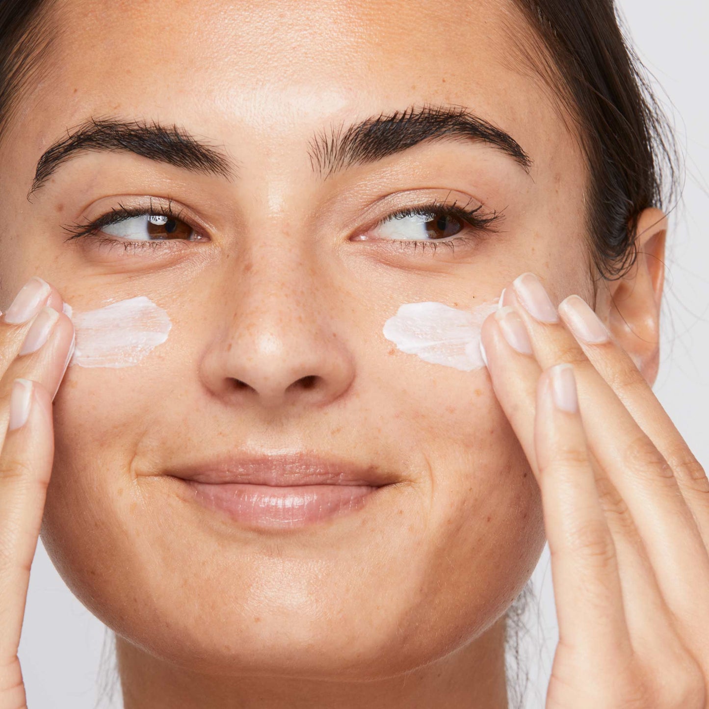 woman applying dynamic skin recovery spf50 