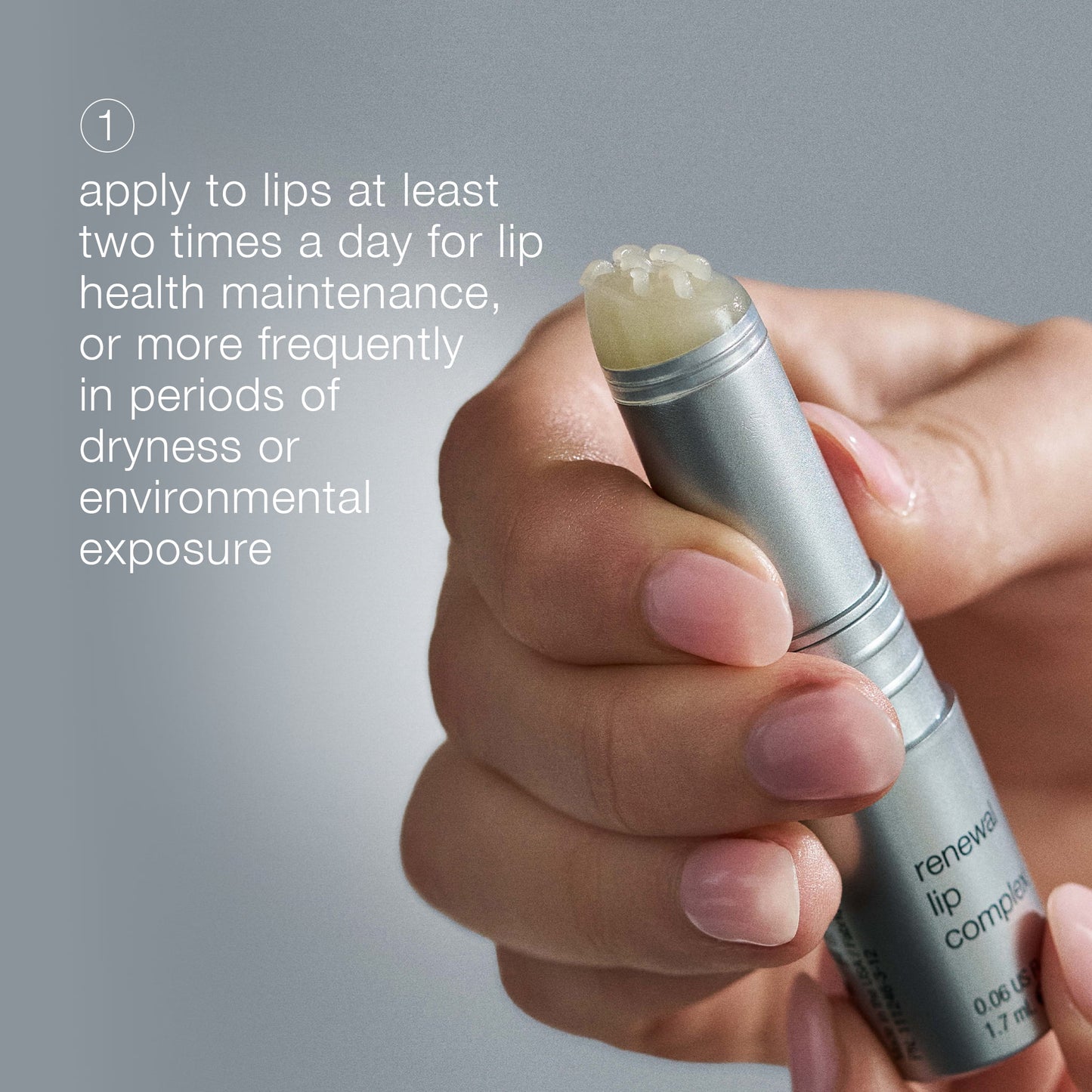 Hand holding a lip balm with text on a gray background 