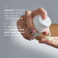 Hand holding a bottle of skincare serum with text on a gray background