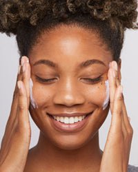 woman applying spf onto face collagen 101 ➔