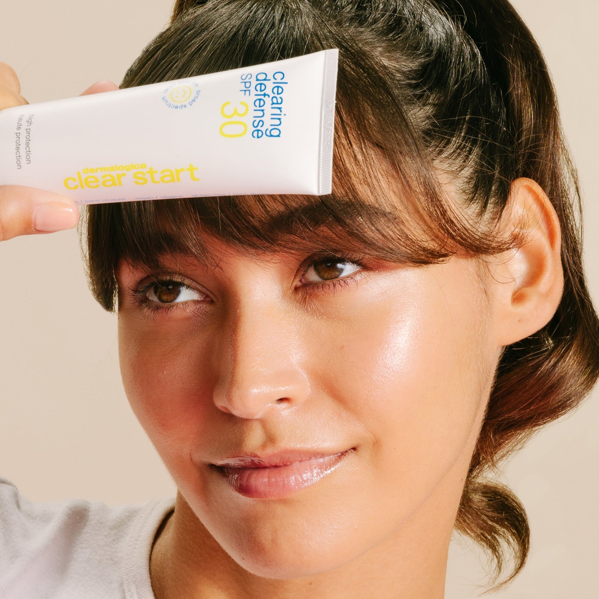 Model holding Clearing Defense SPF 30 to face