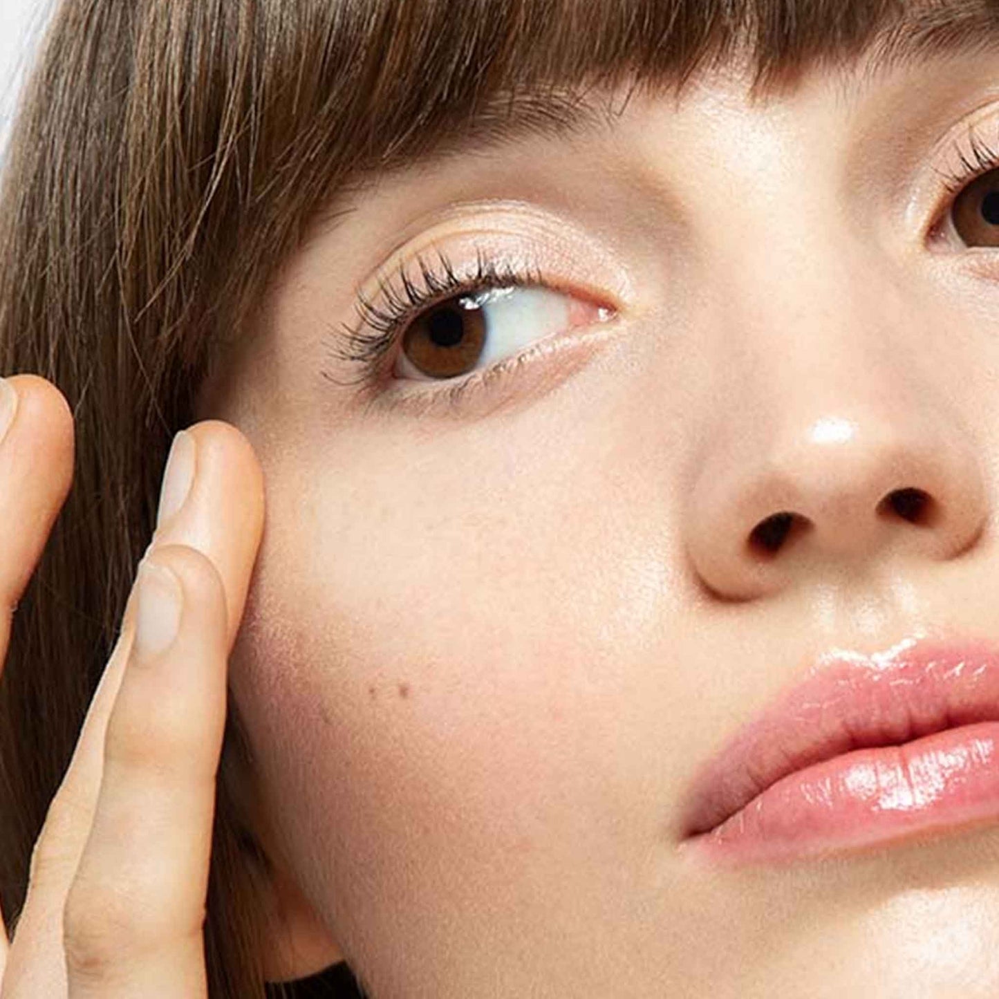 woman applying awaken peptide eye gel