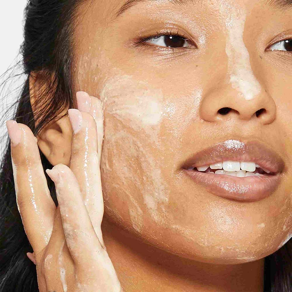 woman cleansing face with daily milkfoliant