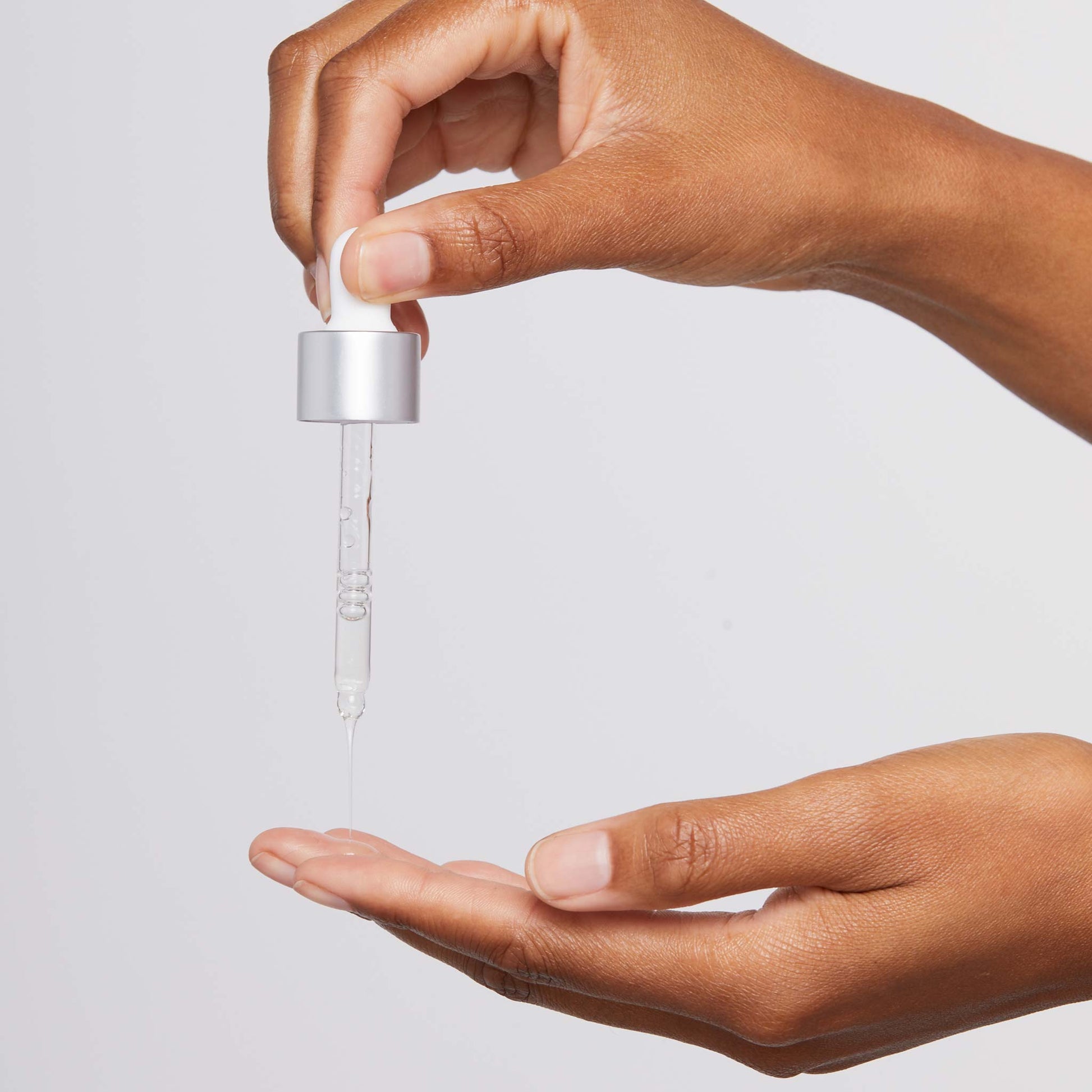 age bright clearing serum being dispensed onto fingertips