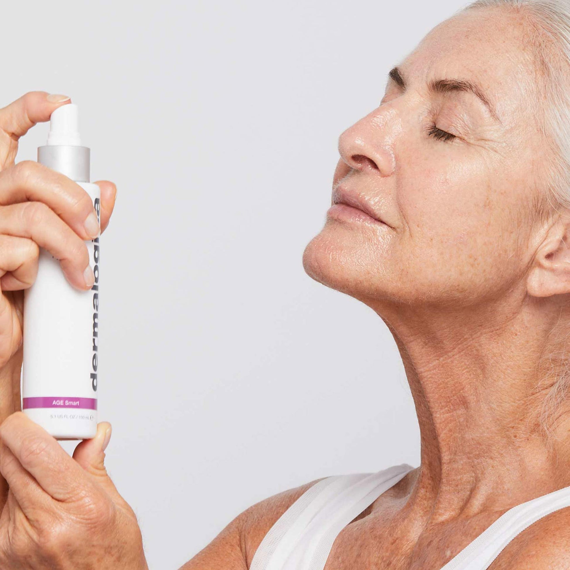 woman spritzing antioxidant hydramist onto face