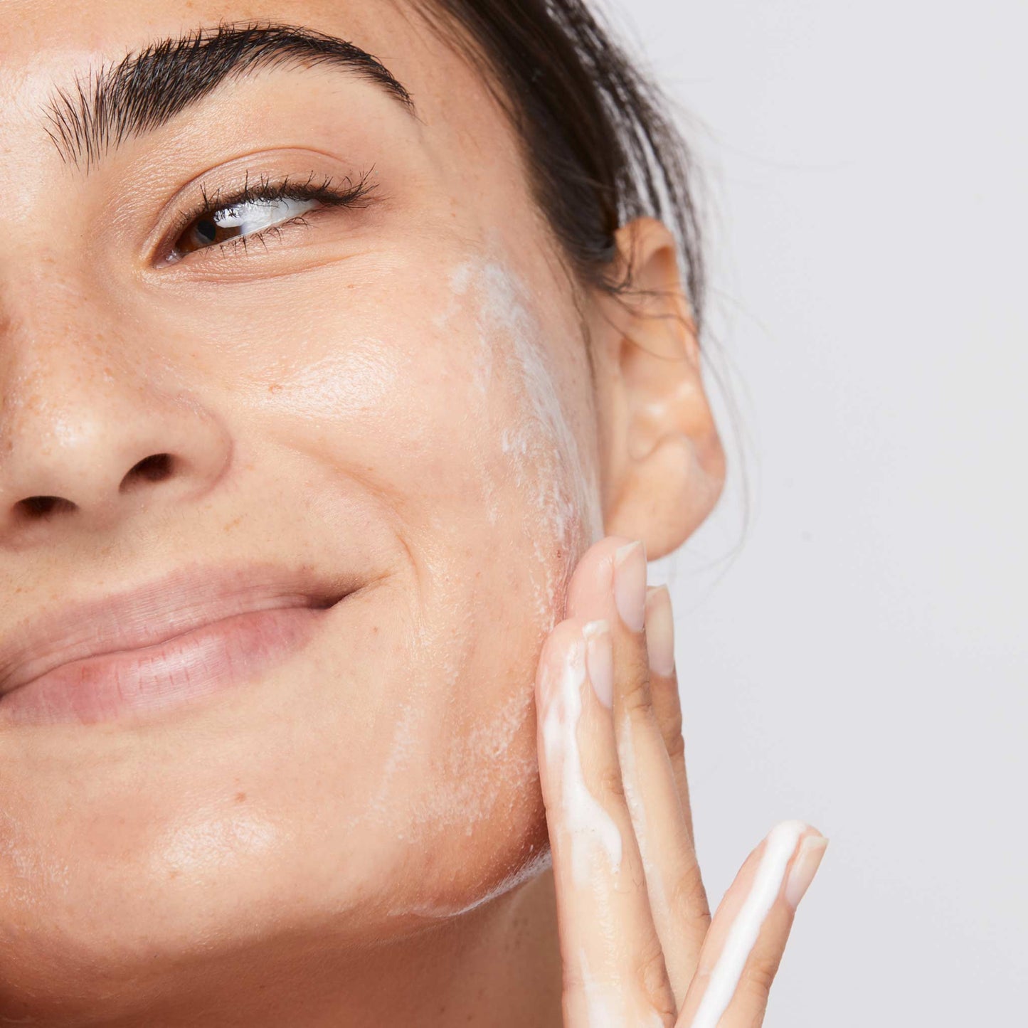 woman cleansing face with clearing skin wash
