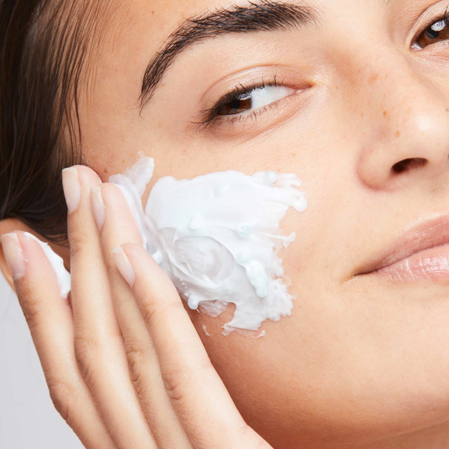 woman applying hydro masque exfoliant to face